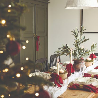 A dining table decorated and set for Christmas with a red, white and green colour scheme