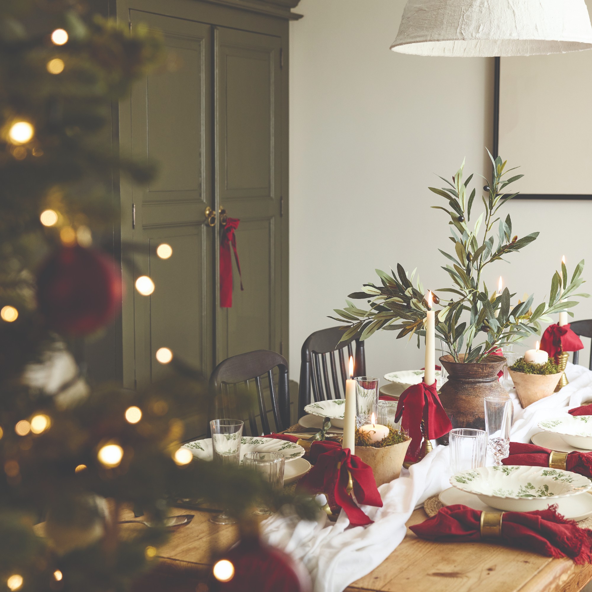 A dining table decorated and set for Christmas with a red, white and green colour scheme