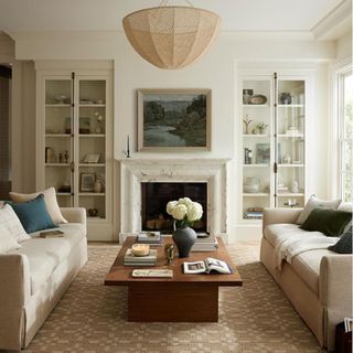 A tan and white area rug in a living room with a neutral color palette