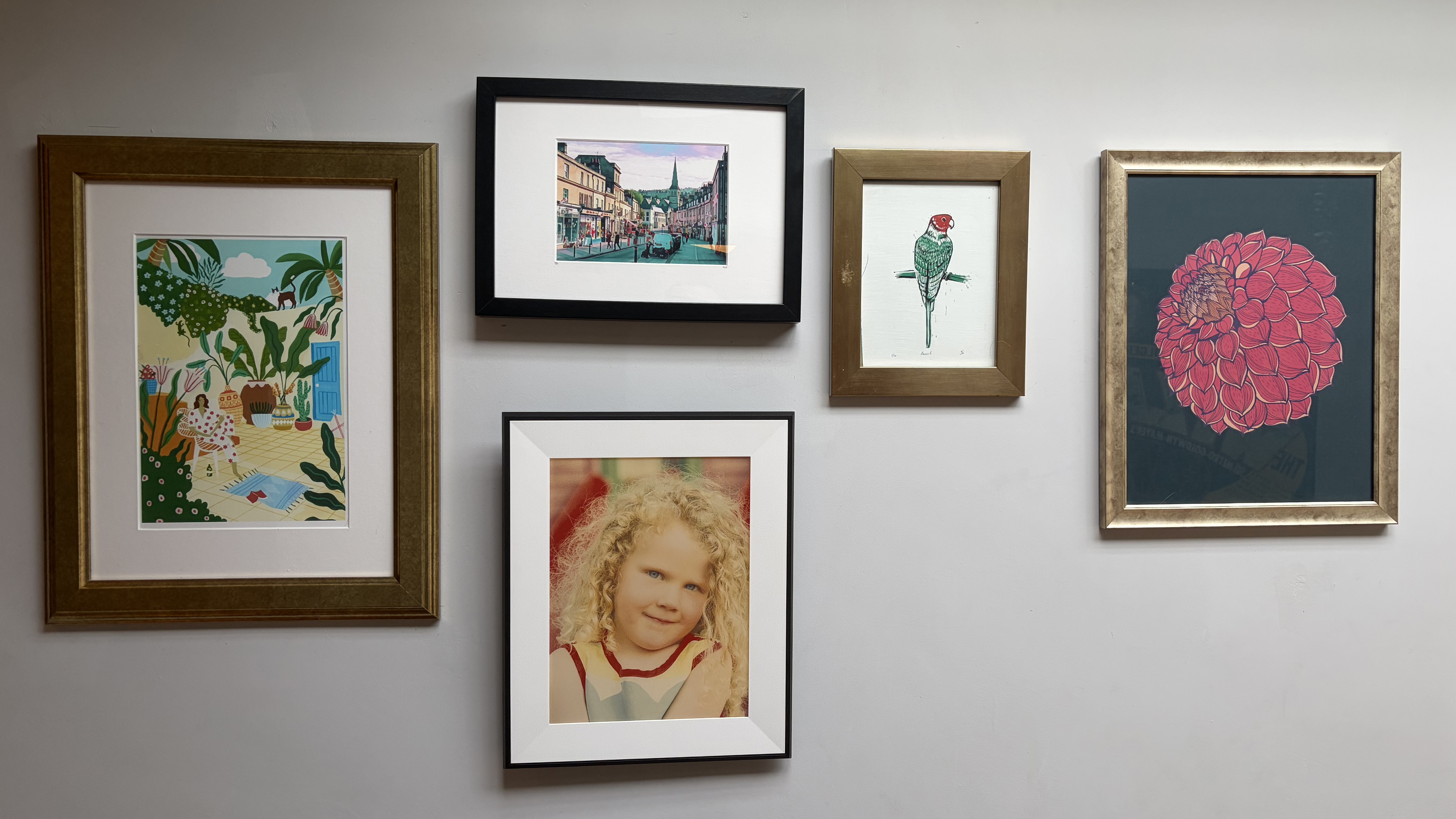 Aura Ink frame hanging on a wall among other wall art