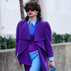 a person wears a purple jacket and blue pants