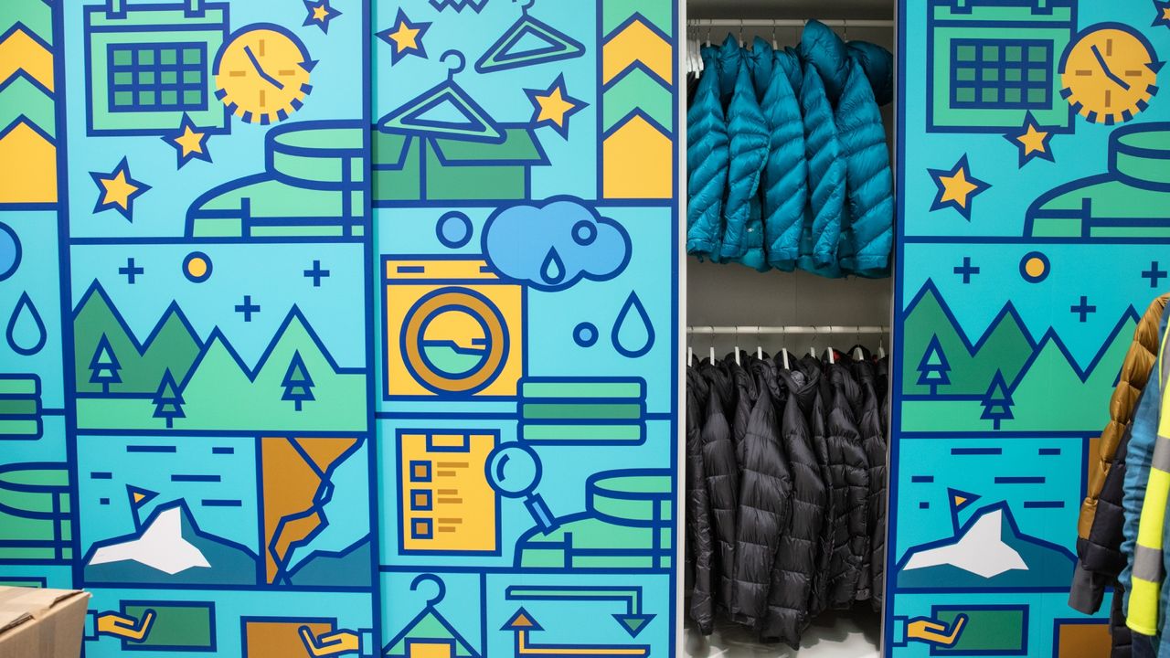 A brightly coloured doors of a wardrobe depicting animated scenes from the outside with one section open to reveal turquoise and black jackets