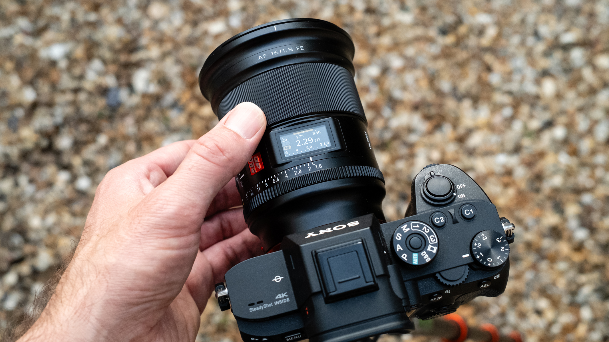 Viltrox AF 16mm f/1.8 FE attached to a Sony A7R III with a hand turning the manual focus ring