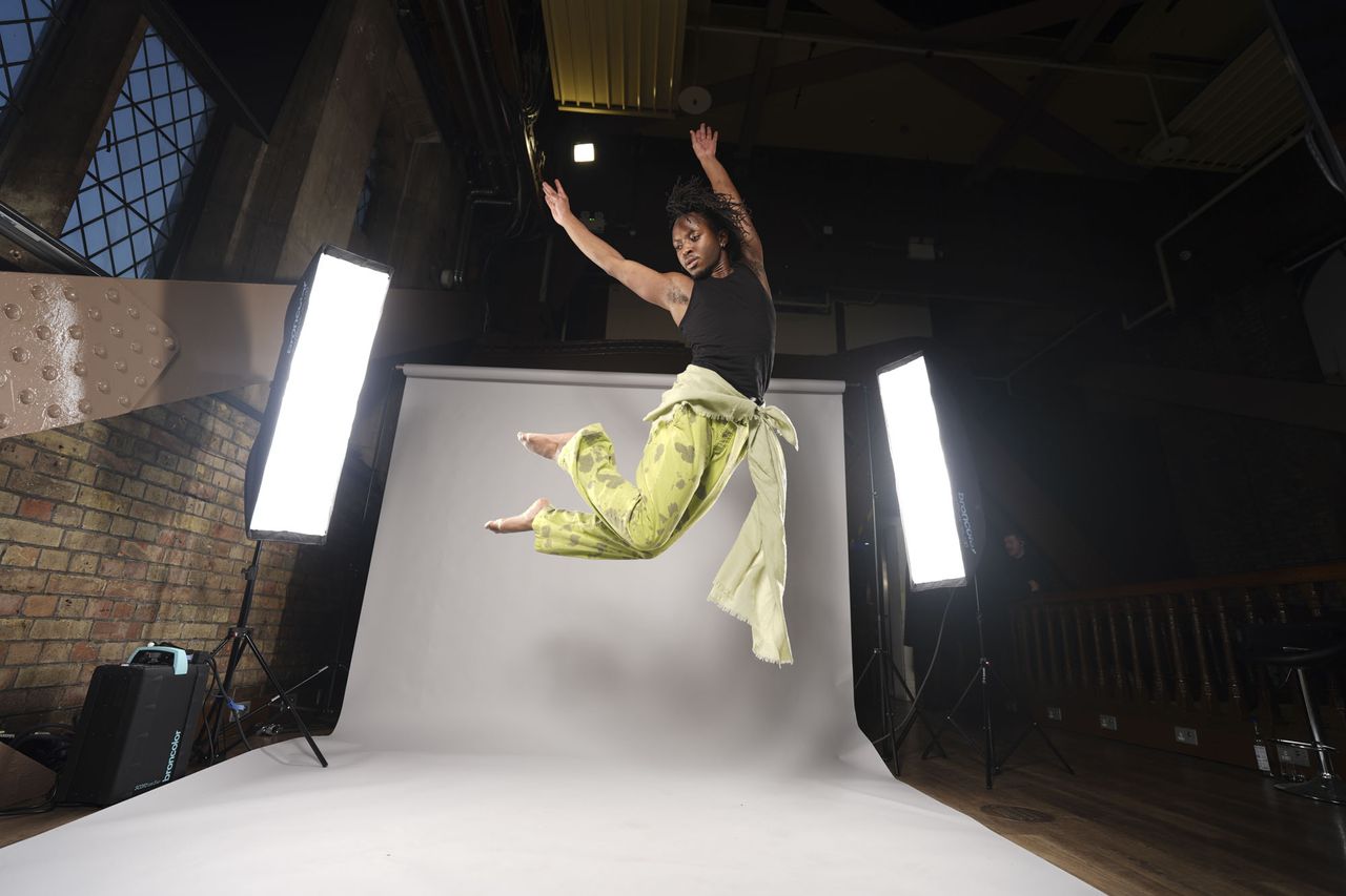 Sony A7 V sample images &ndash; dancer leaping into the air in a studio, with background roll and lights included in the frame