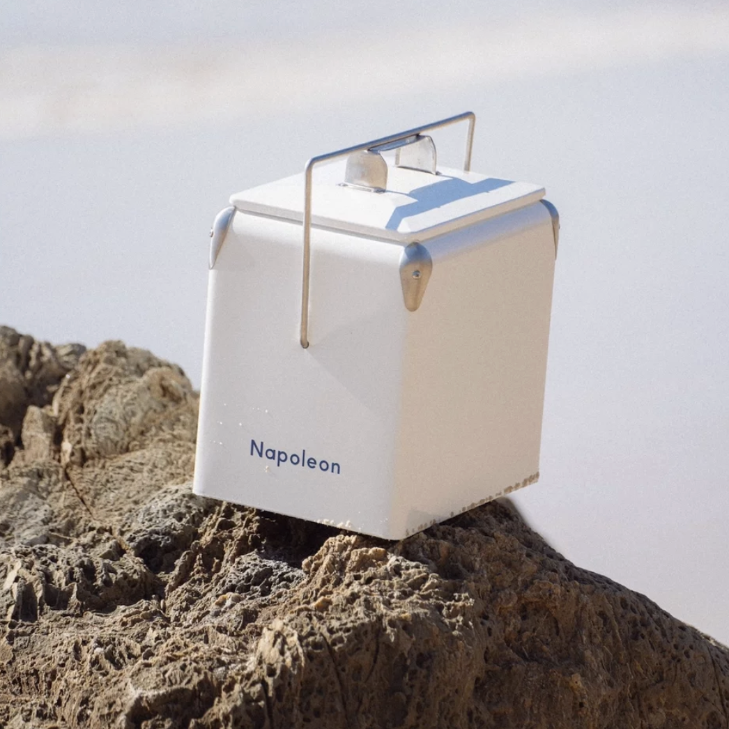 White and blue cooler sitting on a rock