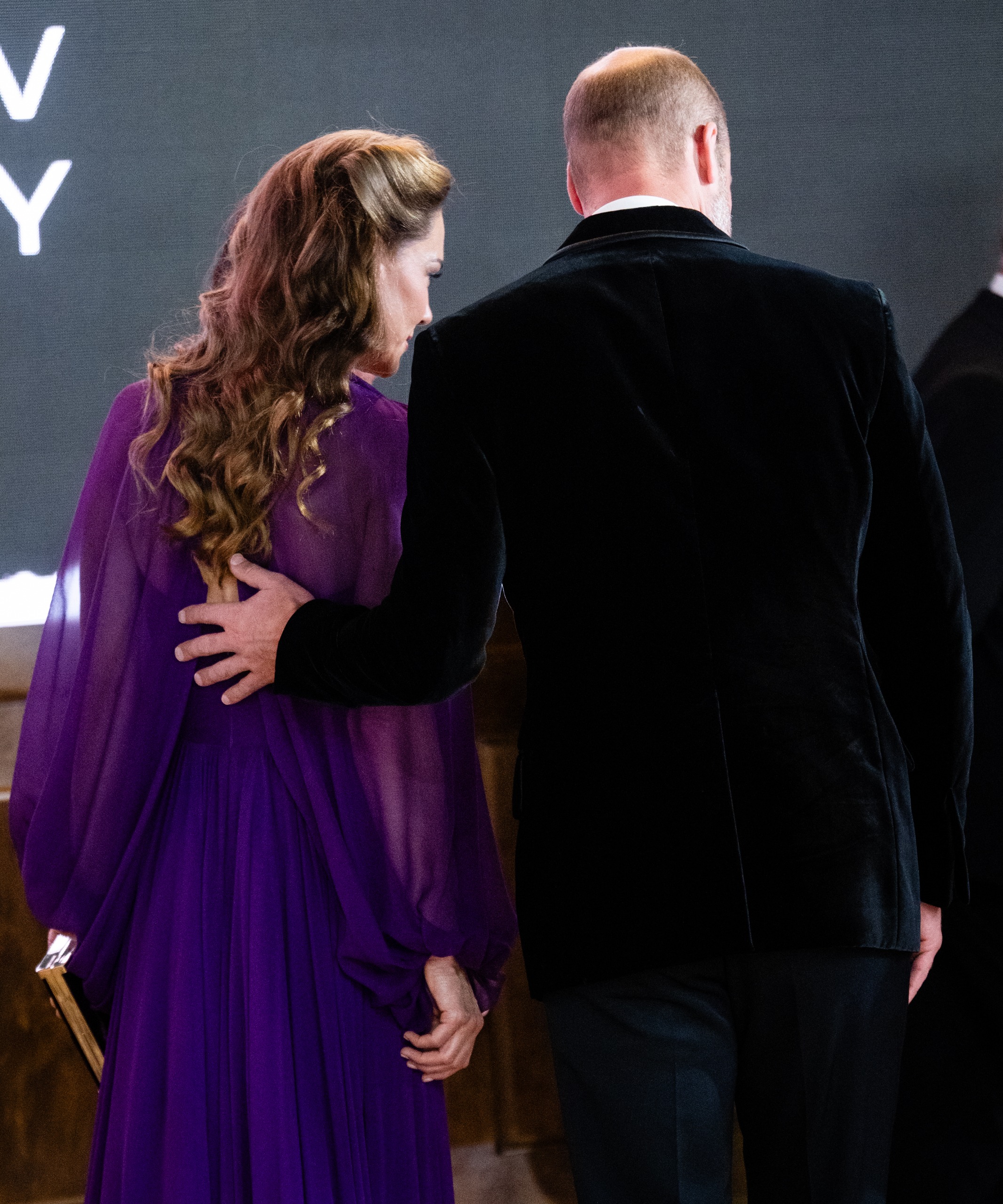 Prince William putting his hand on Princess Kate's back