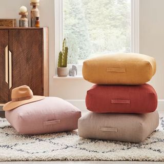 Dunelm floor cushions in terracotta, yellow, pink and grey in living room