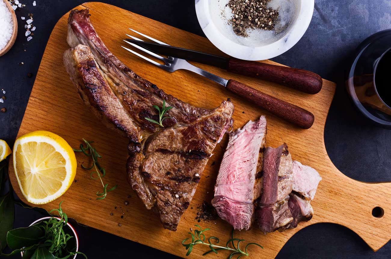 Barbecued ribeye steak on a wooden board