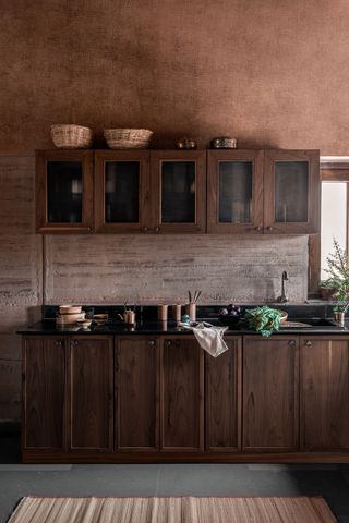 Dark wood rectangular kitchen cupboards, the kitchen side board, a sink.