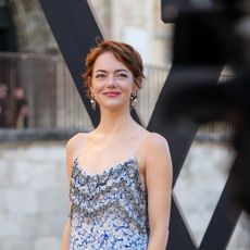 Emma Stone wears a sleeveless dress
