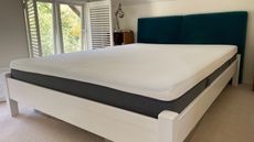 Emma CliMax Hybrid mattress on bed with blue headboard in white bedroom