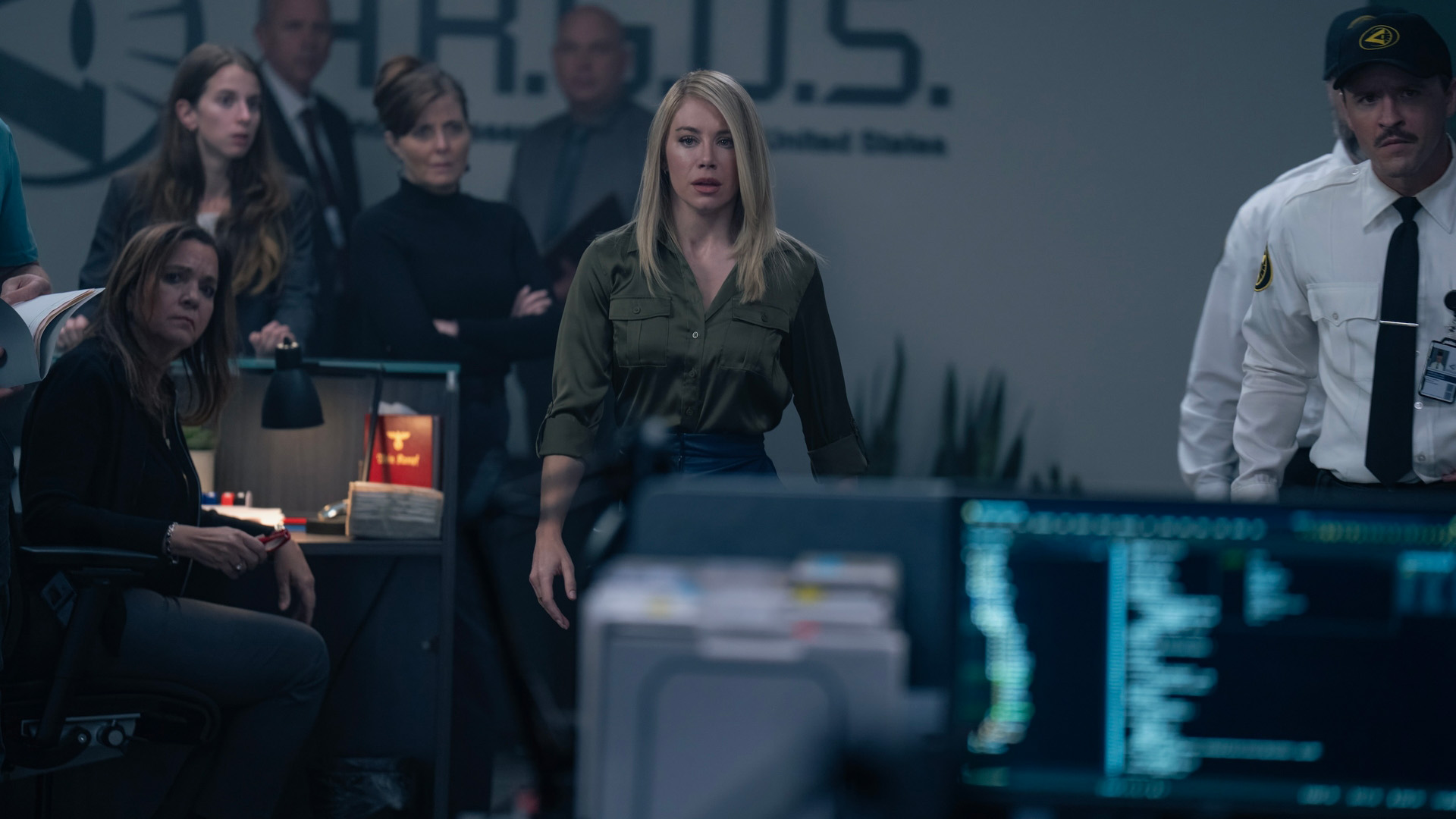 Harcourt (Jennifer Holland) in the A.R.G.U.S. offices in Peacemaker season 2.