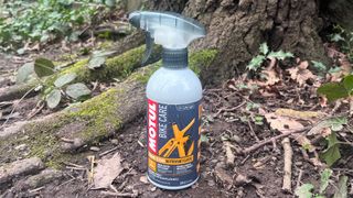 Motul Frame Clean bottle on ground by tree