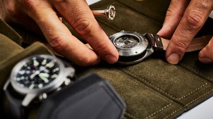 A man taking out watches from one of the best watch rolls, which currently three watches in