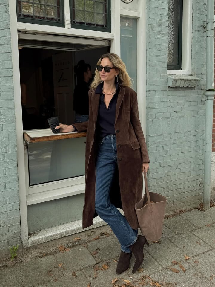 Woman in a brown suede coat and slim jeans