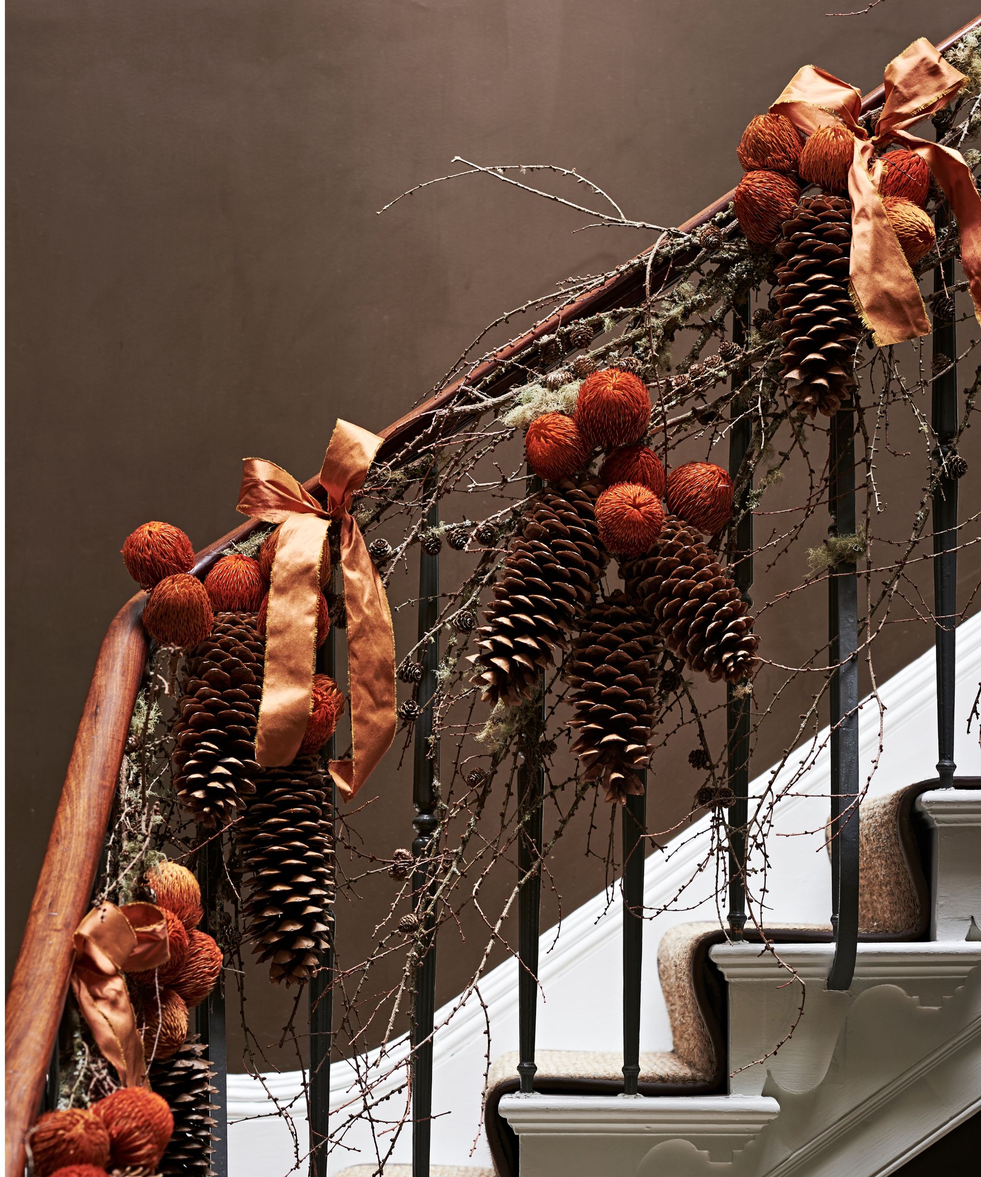 Staircase garland with pinecones, dried oranges and orange ribbons