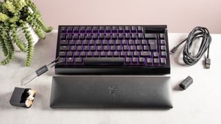 Razer BlackWidow V4 Pro 75% on desk with USB cable, USB dongle, keycap puller, and wrist rest