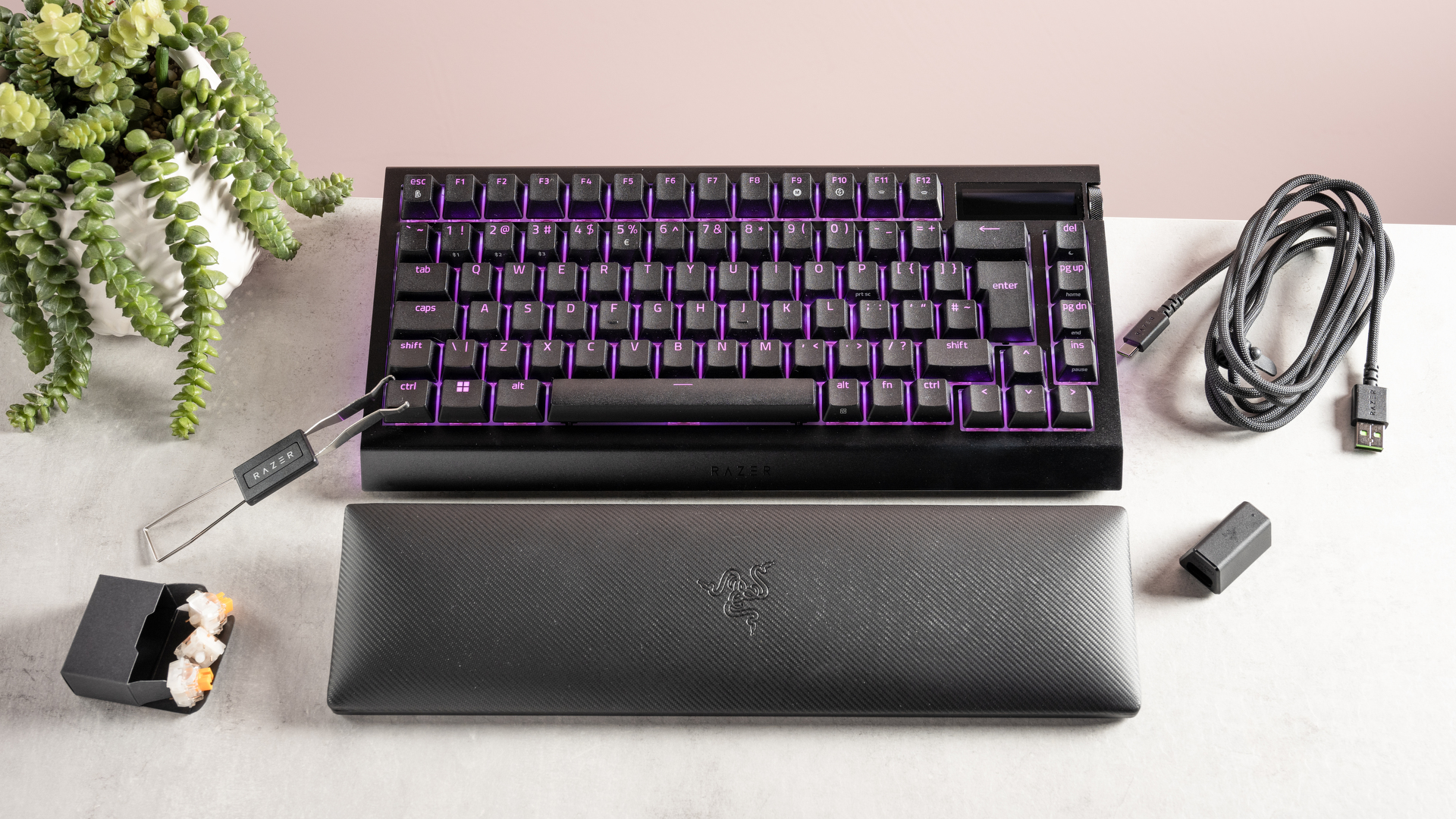 Razer BlackWidow V4 Pro 75% on desk with USB cable, USB dongle, keycap puller, and wrist rest