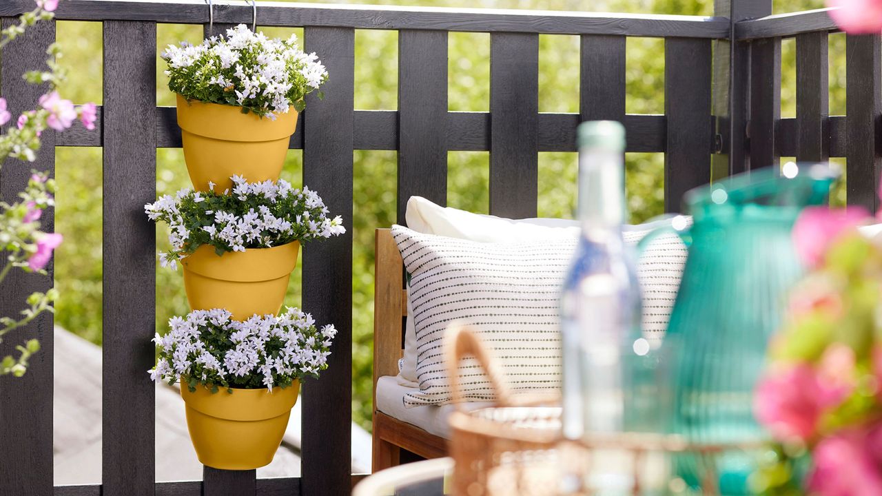 container garden ideas hanging pots on fencing by patio seats