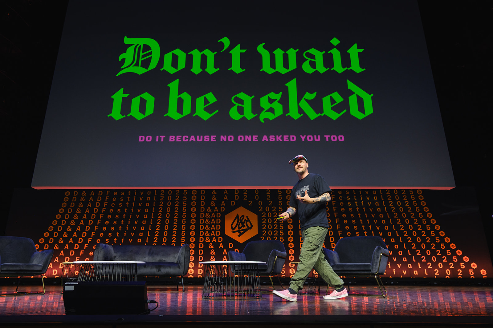 Gavin Strange on stage at D&AD Festival with bright colours behind him and text that says don't wait to be asked