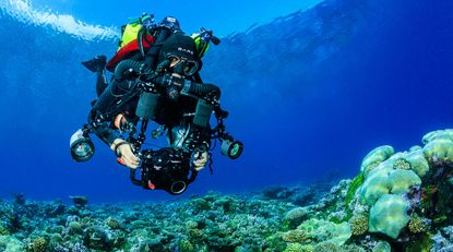 Man underwater holding a camera