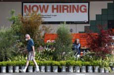 A "now hiring" sign is posted at a Home Depot store