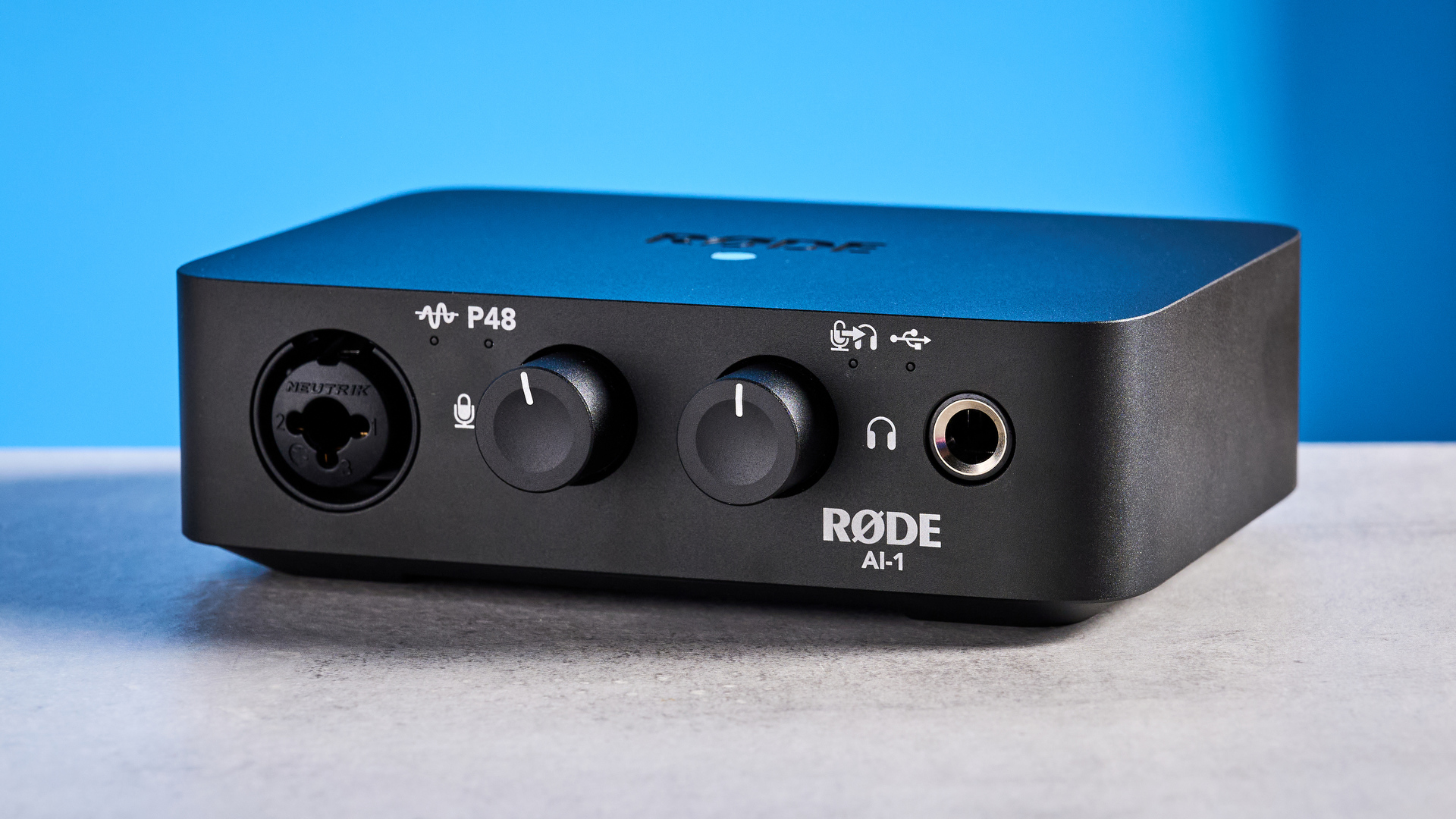 the rode ai-1 audio interface in black with an XLR input, a headphone input, and 2 speaker outputs