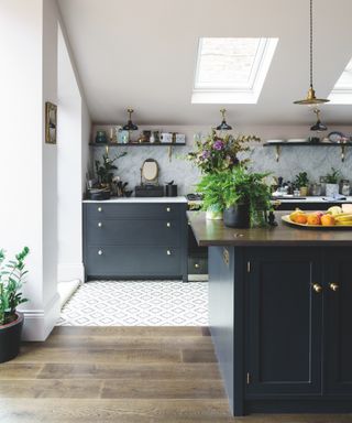 white kitchen with nearly black cabinets in Railings, skylight in ceiling, open shelving, patterned floor tiles, tiled backsplash, kitchen island with flowers