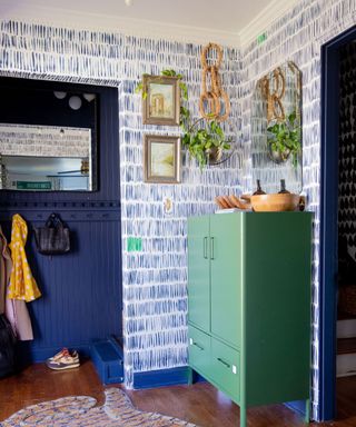 A maximalist entryway with blue and white wallpaper
