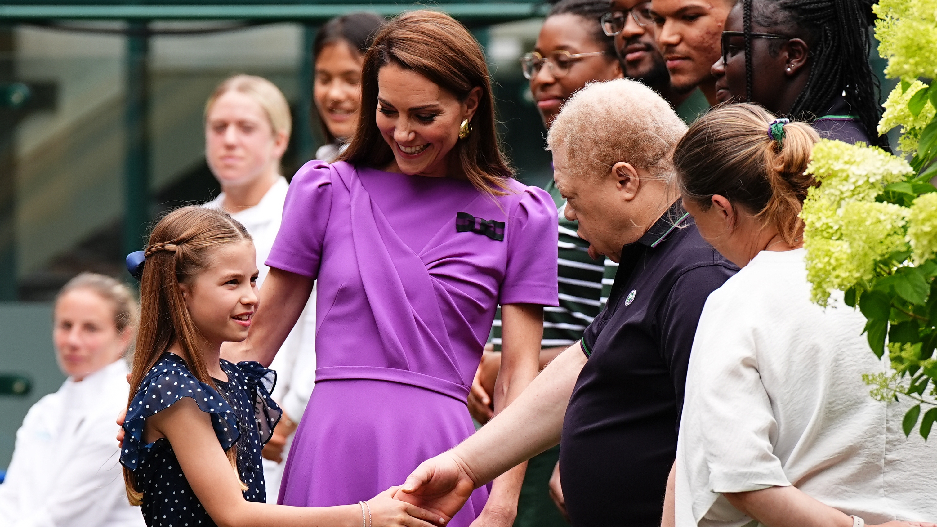 Catherine, Princess of Wales (2nd L) and Princess Charlotte (L) meet ground staff during a visit to the All England Lawn Tennis and Croquet Club on July 14, 2024