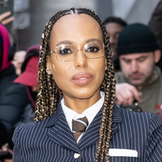 Kerry Washington wearing braids, glasses, and lipstick and posing for camera.
