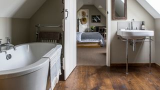 attic en suite bathroom with wooden flooring and green walls