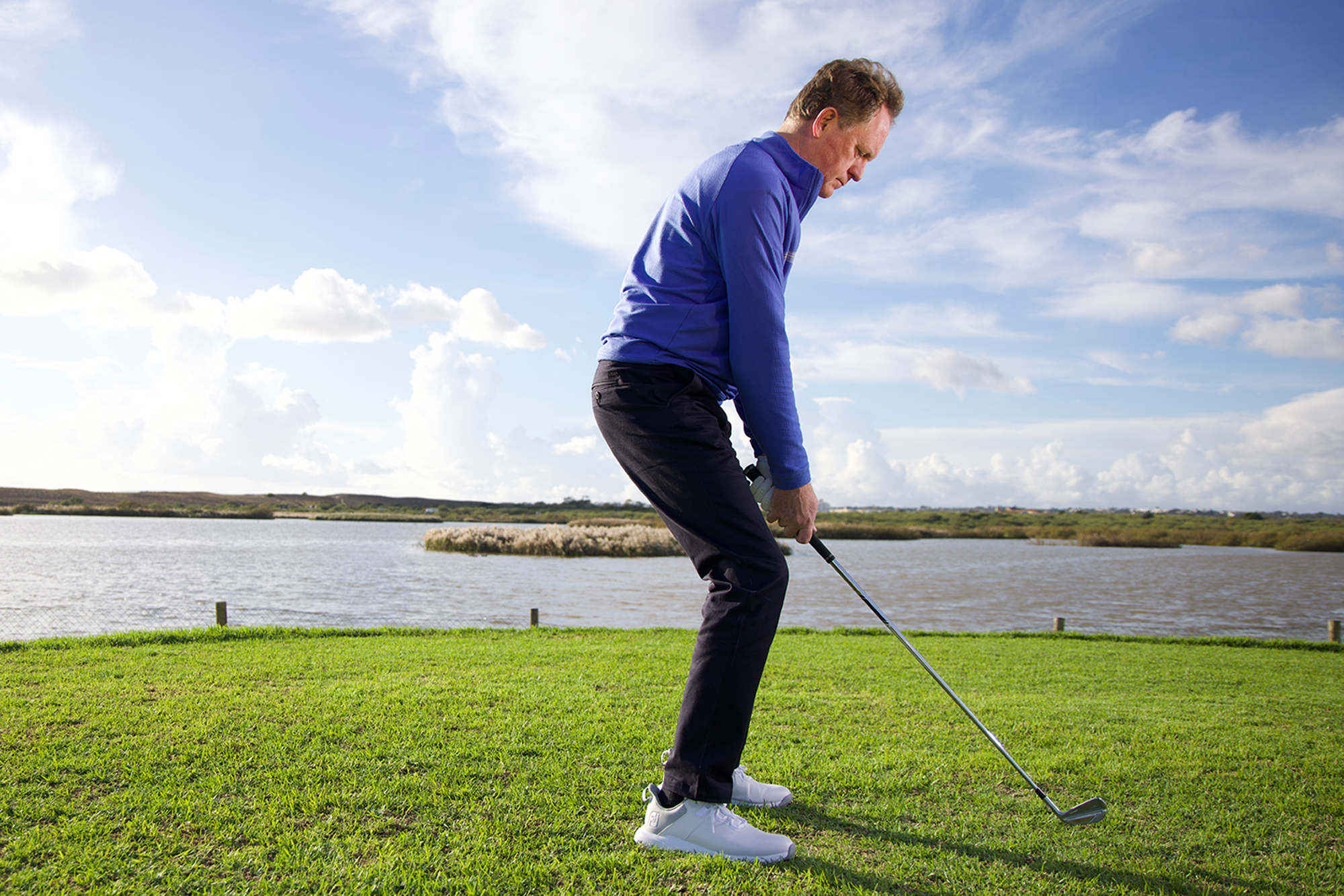 Keith Wood demonstrating an incorrect and inefficient golf swing posture position, with his knees too flexed and hands too close to legs, with back hunched and not an athletic position