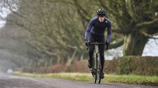 Image shows a rider cycling wearing one of the best long sleeve jerseys for cycling