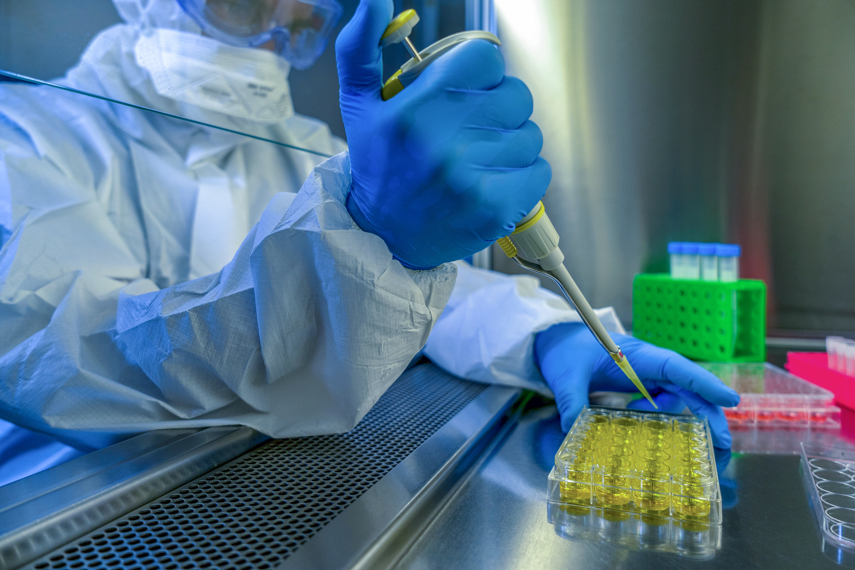 scientist pippeting Oxford vaccine into dish