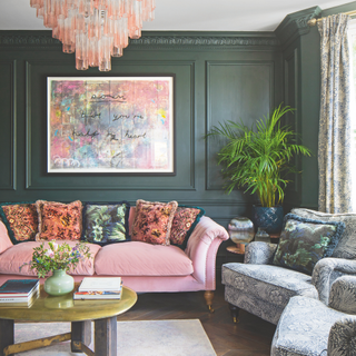 A green jewel-toned living room with patterned sofas.