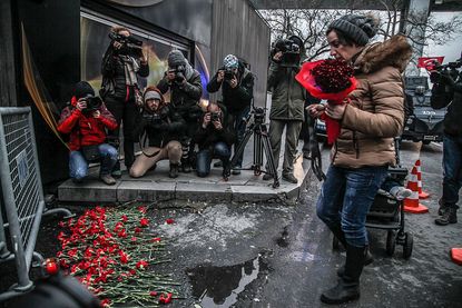 A woman places flowers outside the Reina nightclub in Istanbul