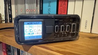 Acefast Z4 218W GaN charger against a bookshelf