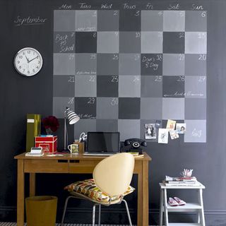 blackboard with paint calendar on wall and desk
