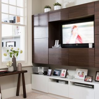 Family TV room with walnut storage unit on the wall