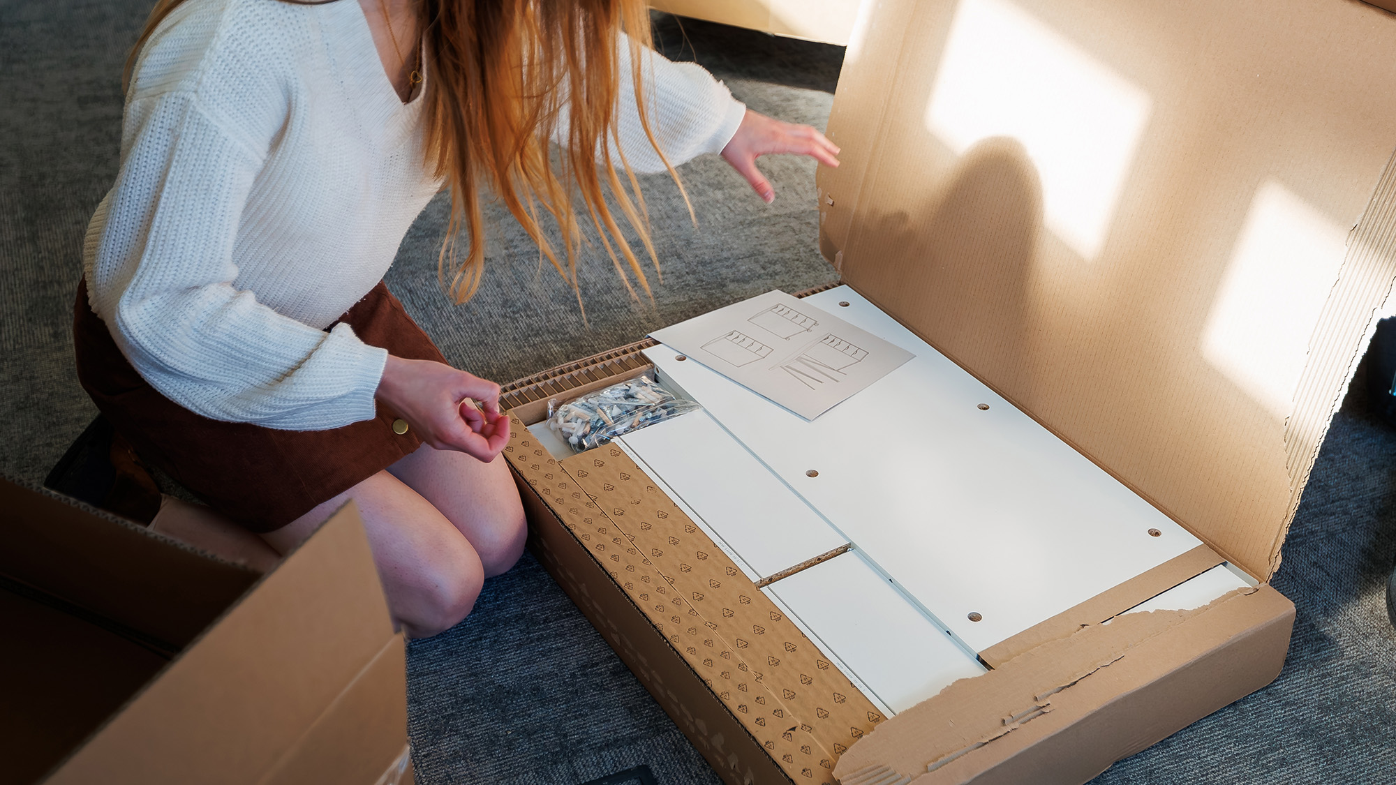 Woman unboxing flat-pack furniture