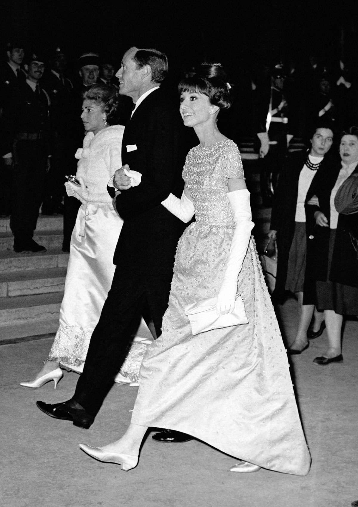 Audrey Hepburn wearing white gloves and an A-line gown at the Cannes Film Festival.