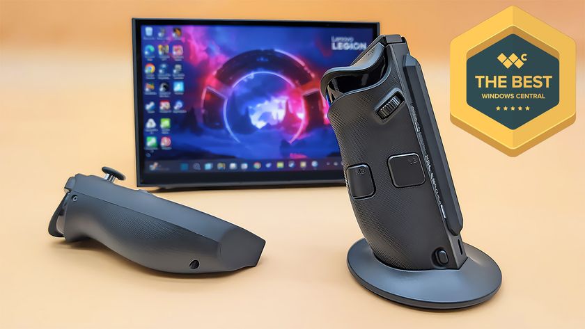 The Lenovo Legion Go 2 right controller in its FPS mode base with the let controller lying down. The Legion Go 2 is propped up on its kickstand behind them. 