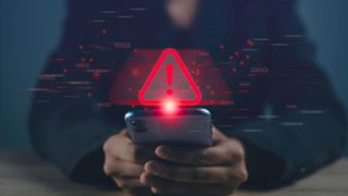 A person looking at a phone with a digital warning sign over it