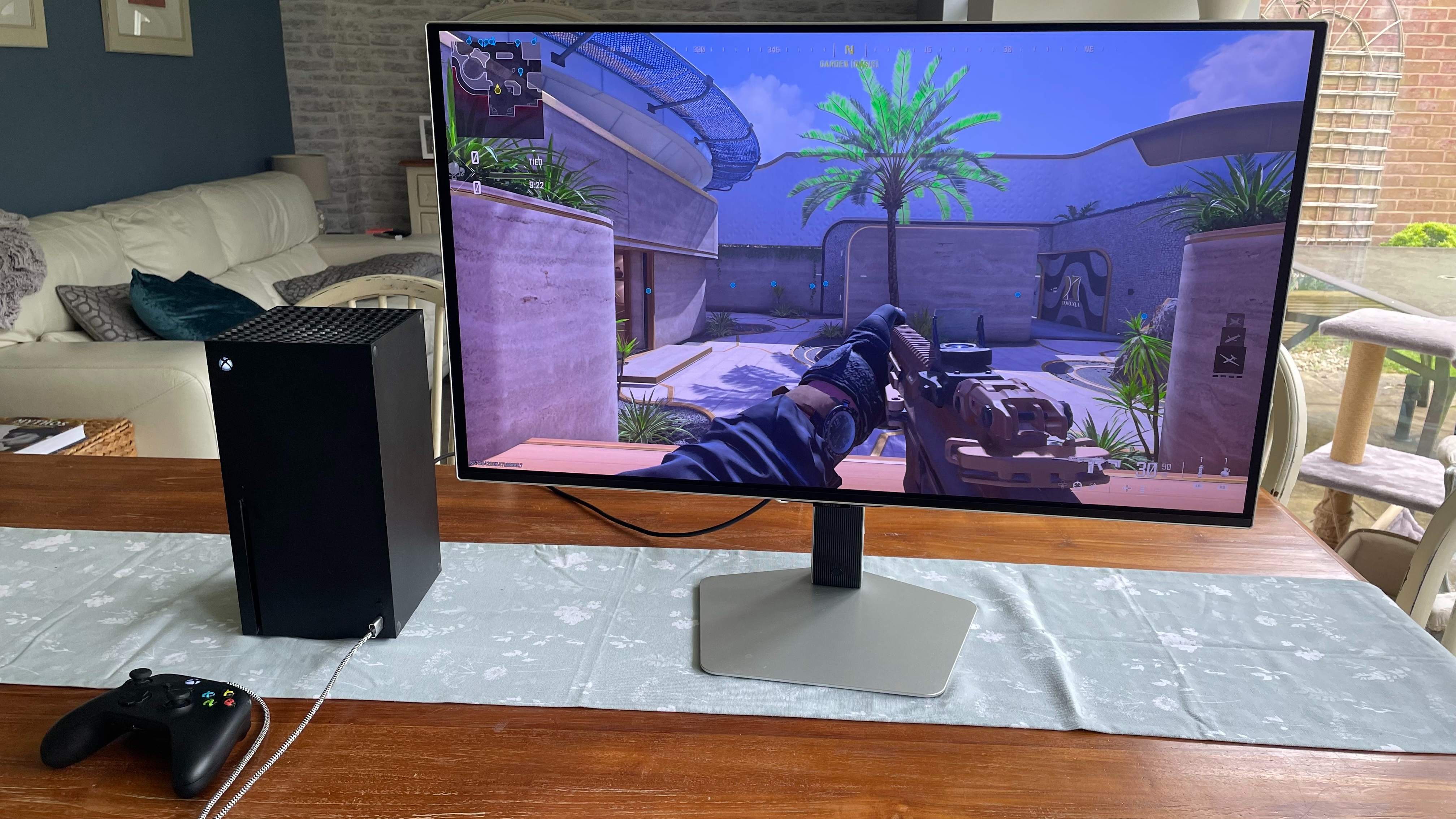 The Samsung Odyssey S32G80SD gaming monitor on a table with an Xbox Series X