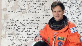 photo of a smiling man in an orange flight suit, superimposed over a blown-up image of a diary entry written in hebrew