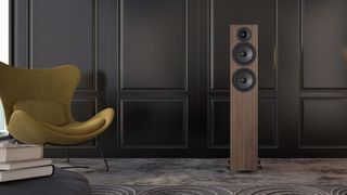 One walnut floorstander in a living room setting next to a yellow chair