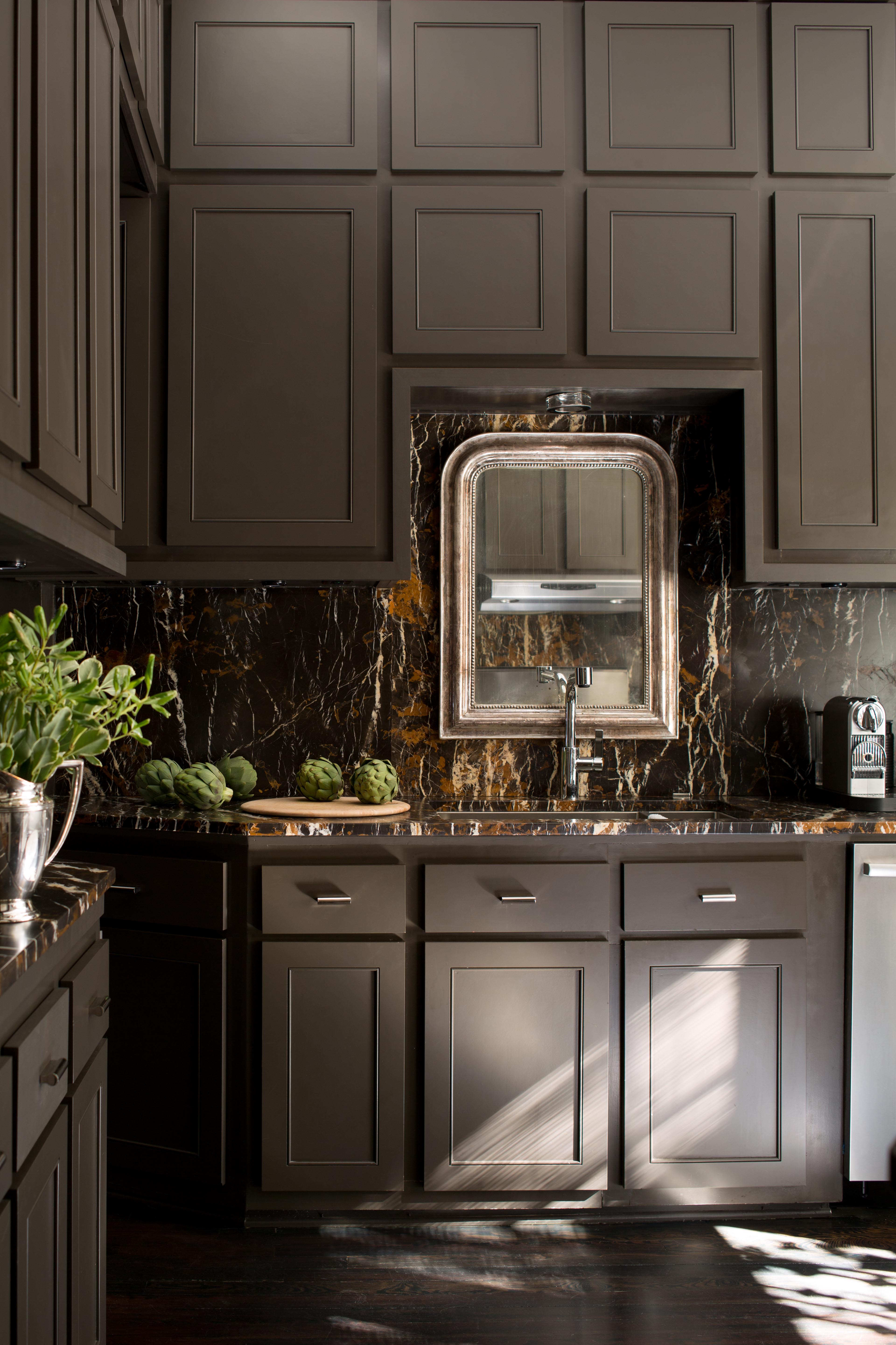 A kitchen with cabinets in moldings, all painted brown