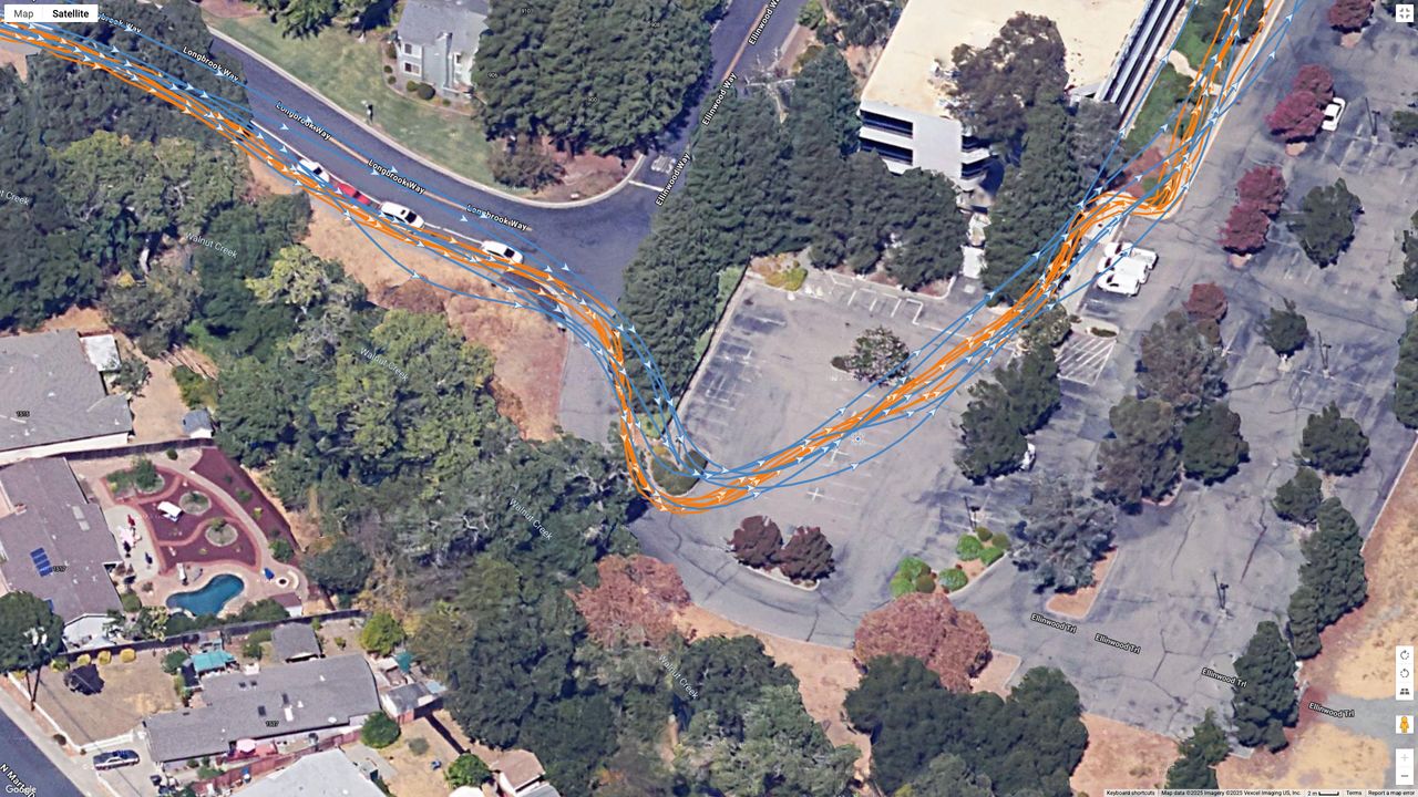 A Google Earth satellite map showing the GPS path of the Samsung Galaxy Watch 8 Classic (blue) and Garmin Forerunner 970 (orange) worn by the same runner.