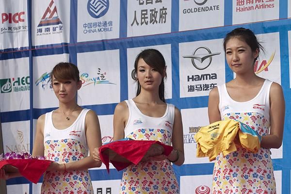 Podium girls await their duties on stage in Sanya.